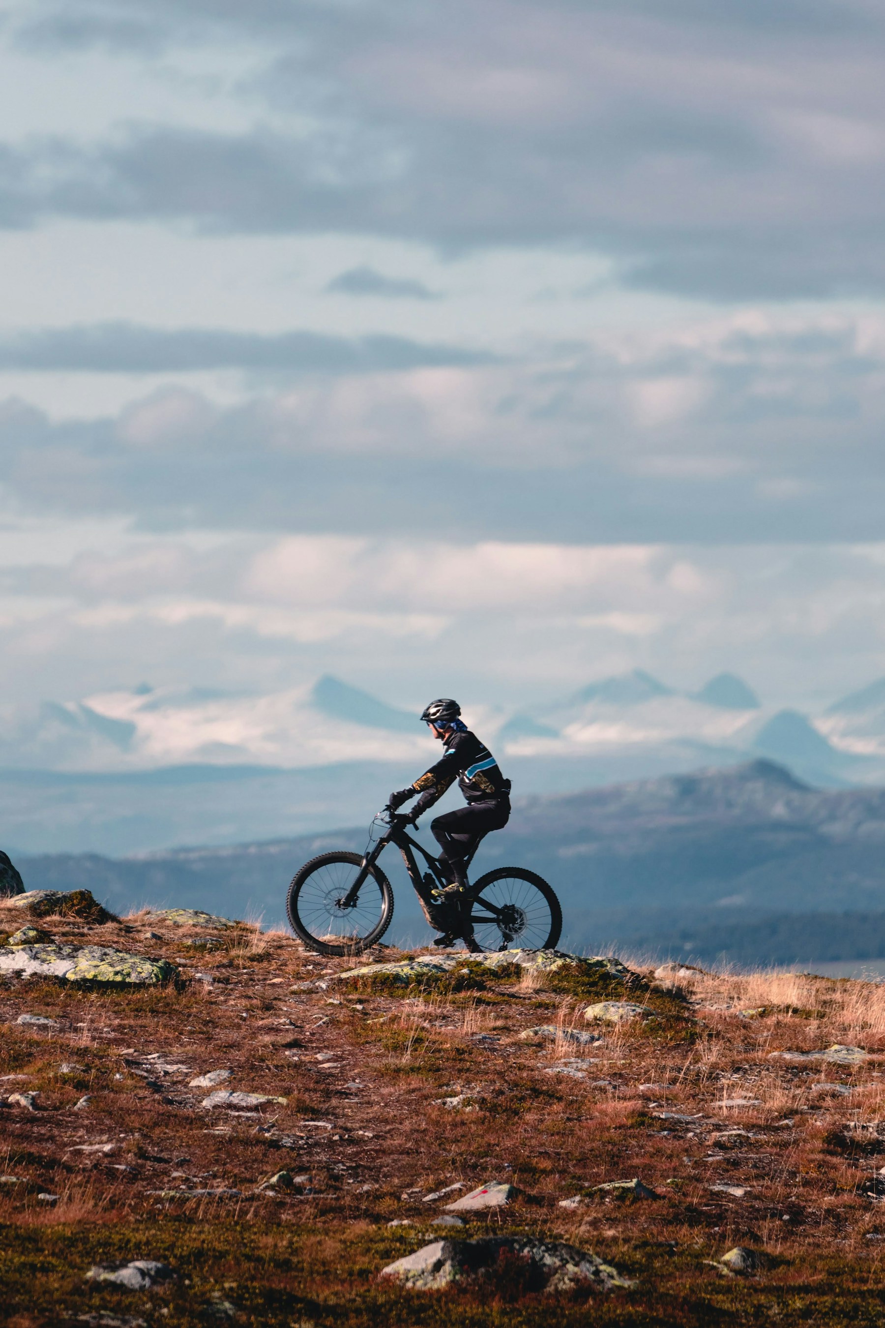 Vététiste sur une crête naturelle avec les Alpes en arrière-plan