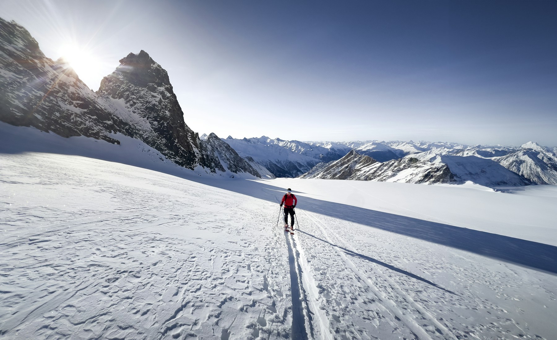 Skieur de randonnée progressant sur un glacier alpin